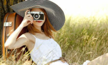 Woman with vintage camera sitting outdoors